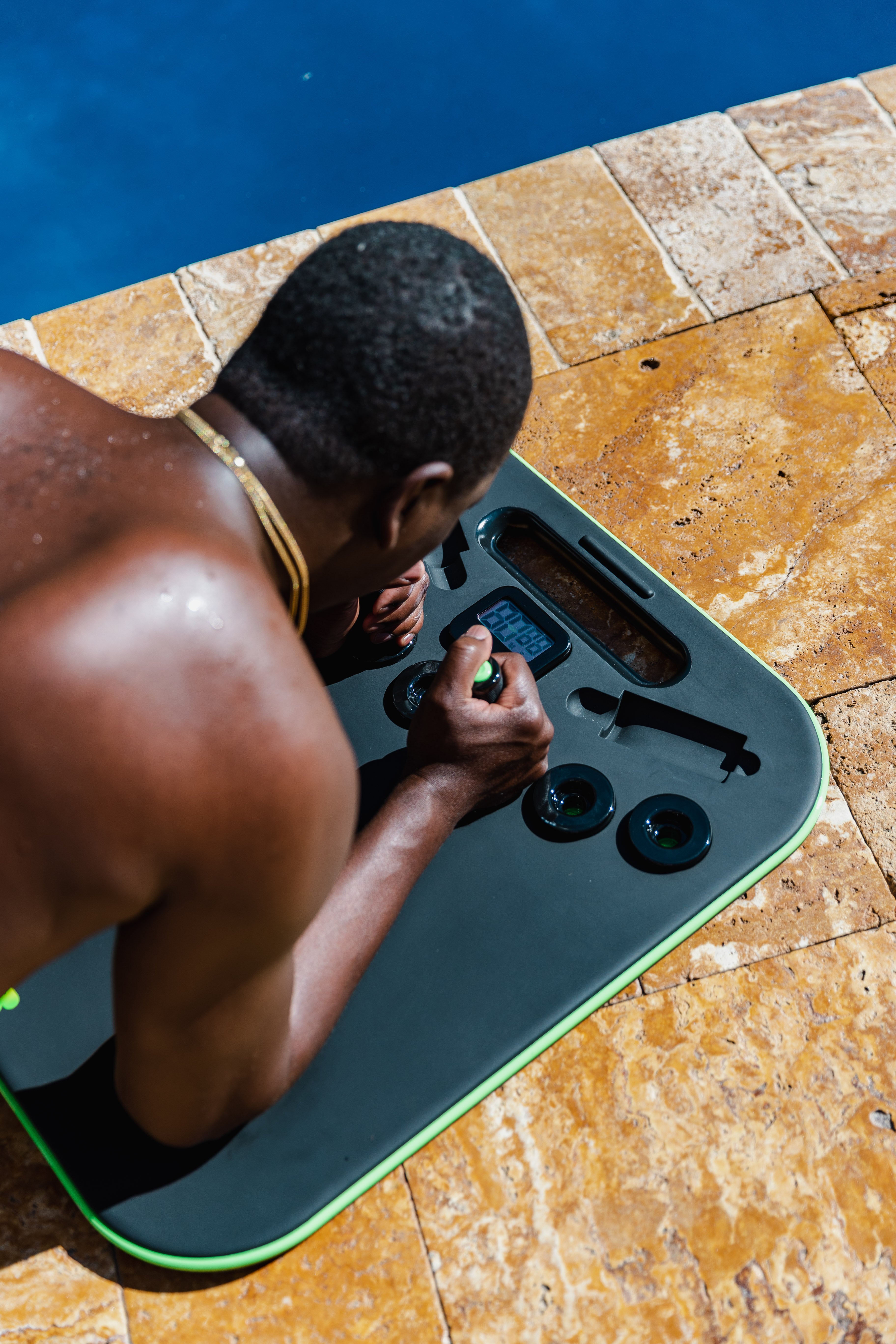 Person using a black exercise board by a pool.