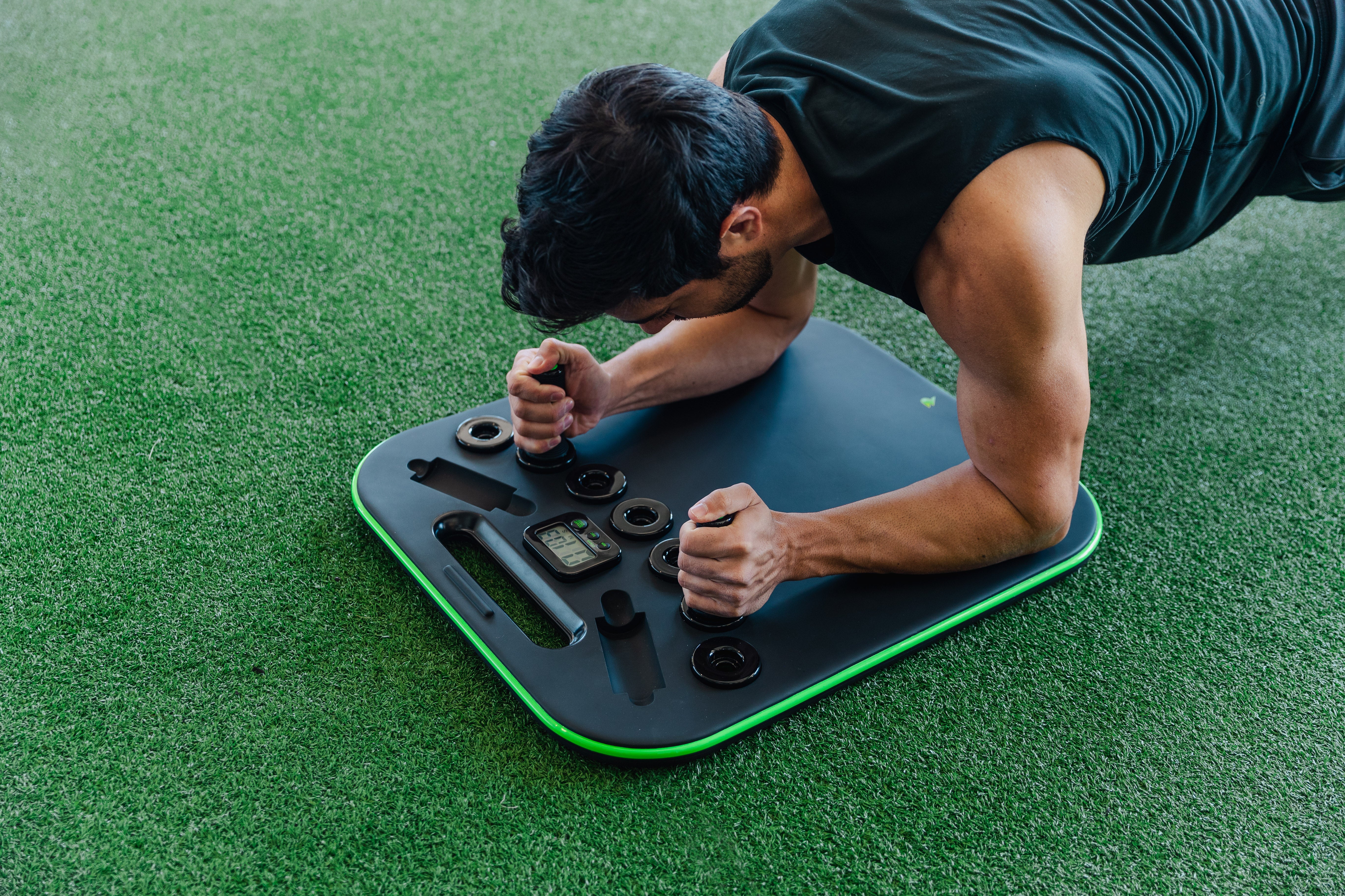Person doing a plank on a fitness board on grass.
